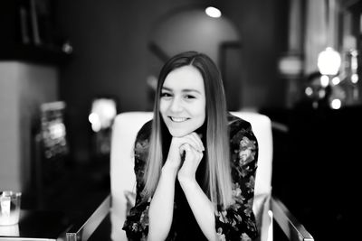 Portrait of beautiful young woman sitting on chair