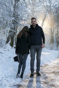 Portrait of young couple standing in snow