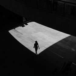 High angle view of silhouette man walking on floor