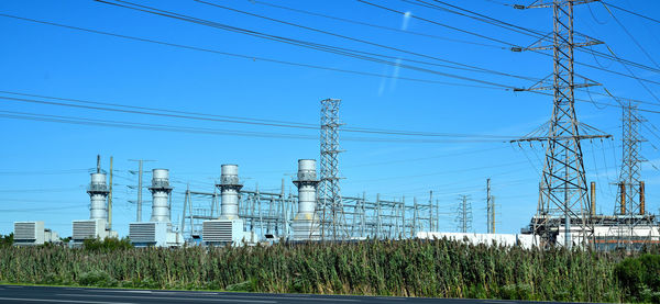 Electricity pylon on field against sky