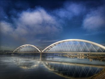 Arch bridge over river against sky