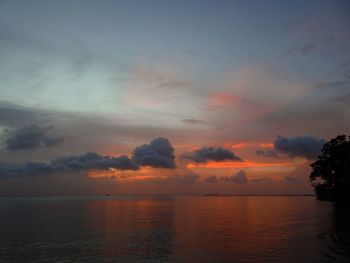 Scenic view of sea against dramatic sky during sunset