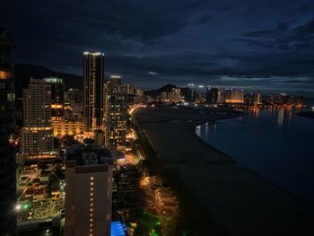 High angle view of illuminated buildings against sky at night