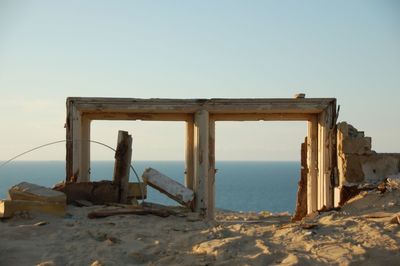 Abandoned built structure on beach against clear sky