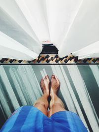 Low section of man standing on tiled floor