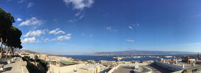 Panoramic view of city against cloudy sky