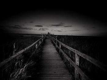 Footpath amidst field against sky