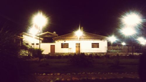 Illuminated house against sky at night