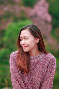 Mid adult woman wearing sweater while standing in park