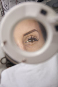 Close-up of patient eye seen through magnifying glass at medical clinic