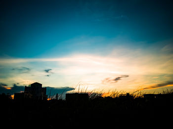 Silhouette buildings against sky during sunset