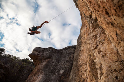 Low angle view of helicopter on rock against sky