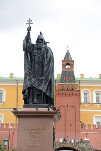 Statue of buddha against sky in city