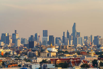 Aerial view of buildings in city against sky