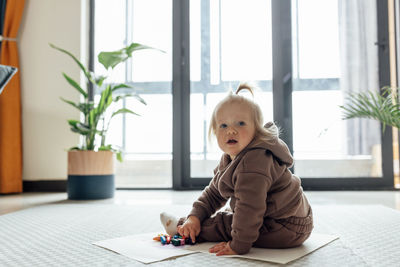 Portrait of cute baby boy sitting at home