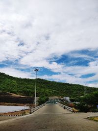 Road amidst trees against sky in city