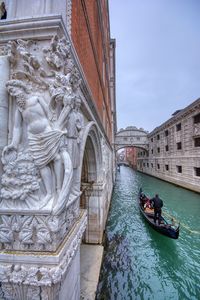 View of boats in canal along buildings