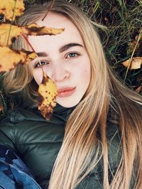 Close-up portrait of a smiling young woman in autumn