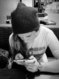 Woman using phone at table in restaurant