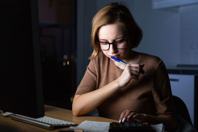 Businesswoman using computer on desk at home