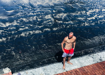 High angle view of shirtless man in sea