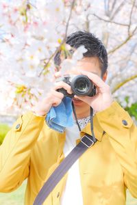 Close-up of man photographing with camera while standing outdoors