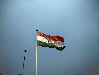 Low angle view of indian flag against blue sky