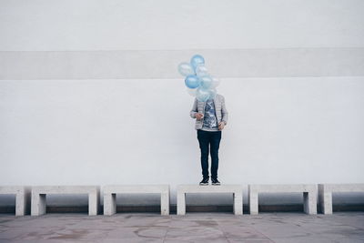 Full length of a man standing with balloons