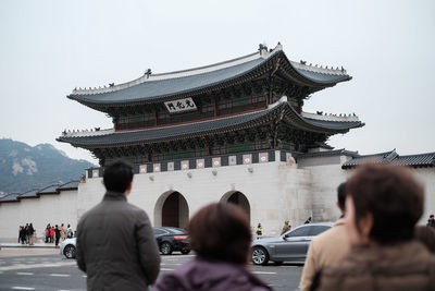 People standing in front of temple against clear sky