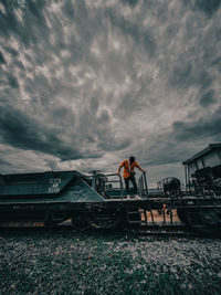 Man working on train against sky