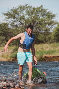 Man with kayak wading in lake