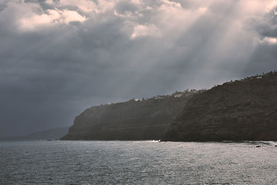 Scenic view of sea and mountains against sky