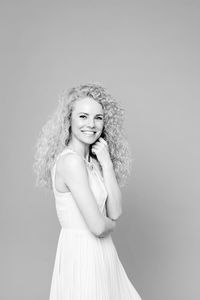 Portrait of a smiling young woman against white background