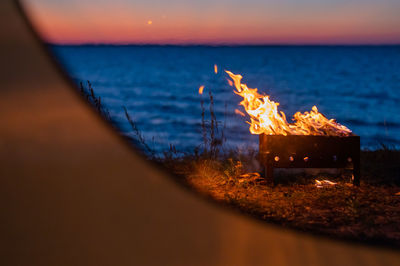 Bonfire on beach against sky during sunset