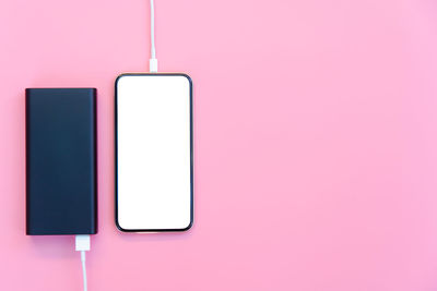 Close-up of laptop on pink wall