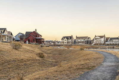 Houses by sea against clear sky