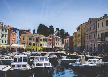 Boats moored in canal amidst buildings in city