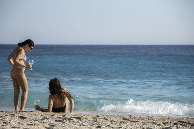 Woman at beach against sky