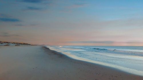 Scenic view of beach against sky during sunset