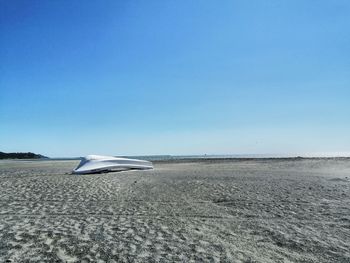 Scenic view of beach against clear blue sky