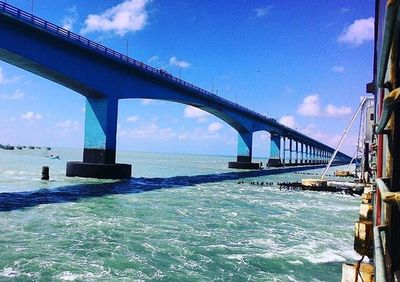 Bridge over sea against cloudy sky