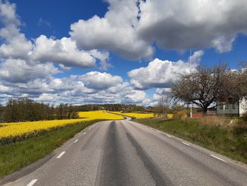 Empty road against yellow sky