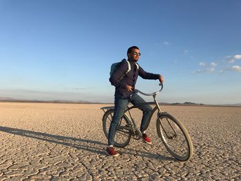 Full length of man with bicycle on landscape against sky