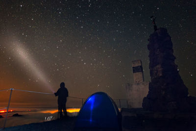 Low angle view of silhouette man standing against sky at night