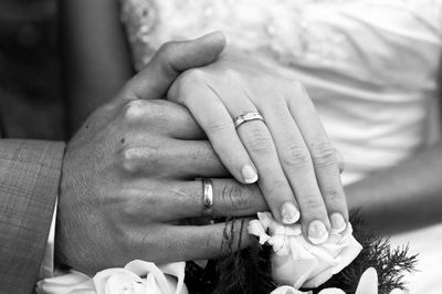 Midsection of couple holding hands during wedding ceremony