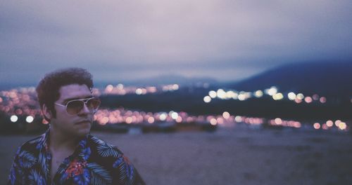 Portrait of young man standing in sea against sky