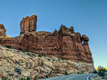 Low angle view of rock formation against clear blue sky