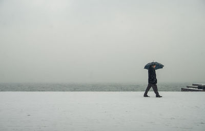 Man standing in sea against sky