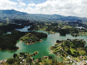 Scenic view of river and mountains against sky