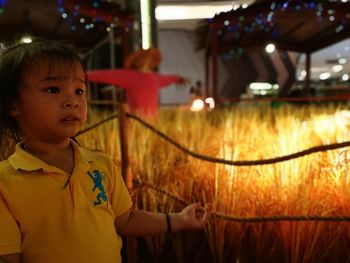 Close-up of boy holding illuminated at night